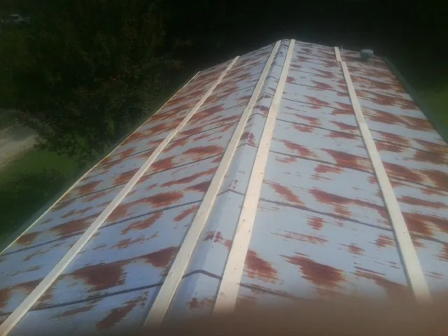 Rusted metal roof panels with new wood purlins before replacement — Storm Damage Roof Repair in Helmville by Roofing Brothers